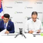 Pastor Dío Astacio y el doctor Santiago Hazim firmando el acuerdo